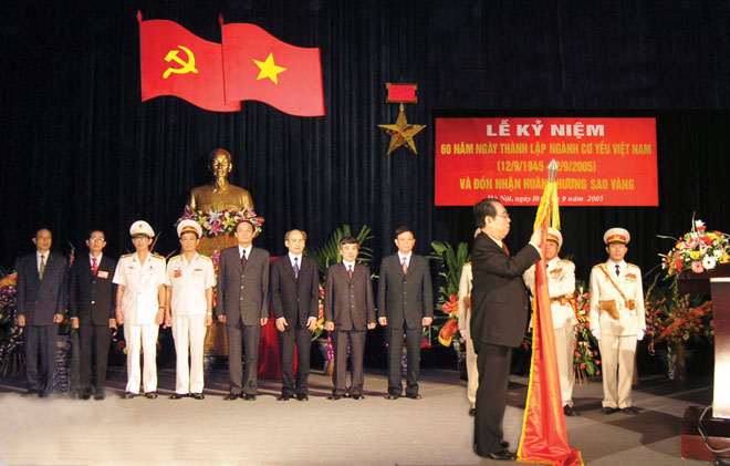 Đồng chí Trương Quang Được, Ủy viên Bộ Chính trị, Phó Chủ tịch Quốc hội gắn Huân chương Sao vàng lên cờ truyền thống trong Lễ Kỷ niệm 60 năm ngày thành lập ngành Cơ yếu Việt Nam (năm 2005)